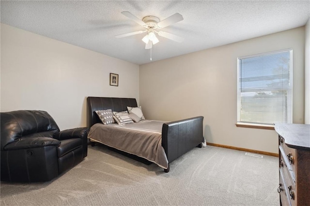 bedroom featuring carpet, ceiling fan, and a textured ceiling