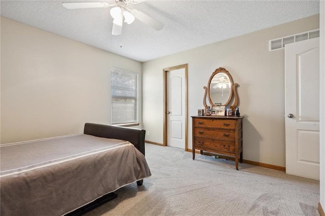 carpeted bedroom featuring a textured ceiling and ceiling fan