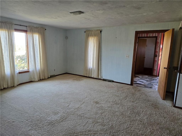 carpeted empty room featuring a textured ceiling