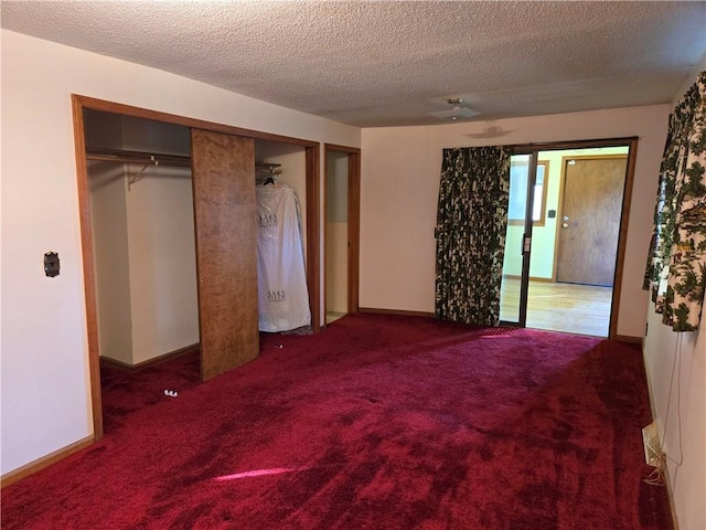 unfurnished bedroom with a textured ceiling, a closet, and carpet