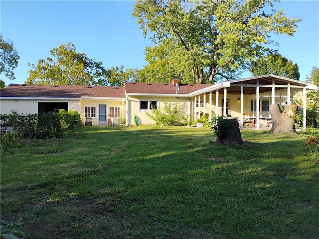 rear view of house featuring a lawn