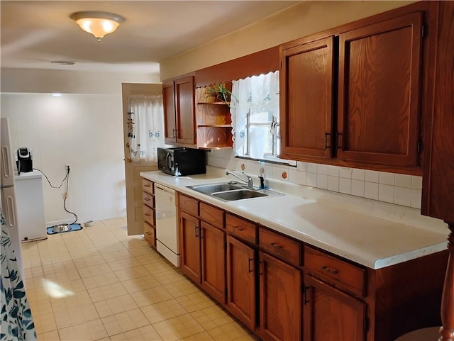 kitchen with decorative backsplash, dishwasher, sink, and light tile patterned floors