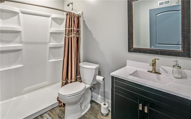 full bathroom with shower / bath combination with curtain, hardwood / wood-style flooring, vanity, and toilet