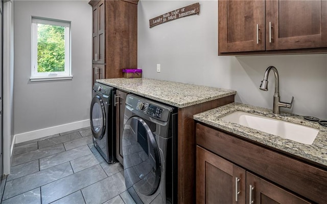 laundry area featuring sink, cabinets, and washer and dryer