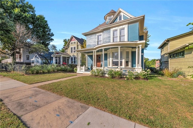 victorian home featuring a porch and a front lawn