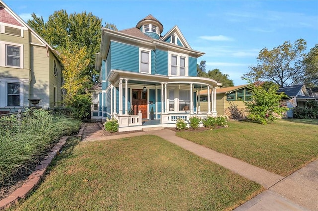 victorian house featuring a porch and a front yard