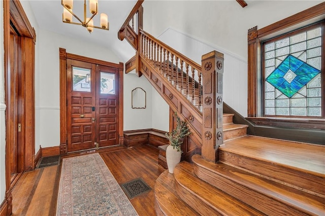 entryway with a notable chandelier and dark hardwood / wood-style flooring