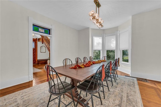 dining room with hardwood / wood-style flooring and a chandelier