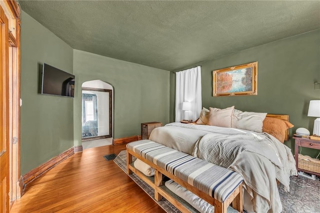 bedroom with light wood-type flooring and a textured ceiling