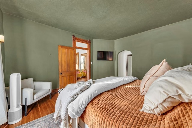 bedroom featuring wood-type flooring and a textured ceiling