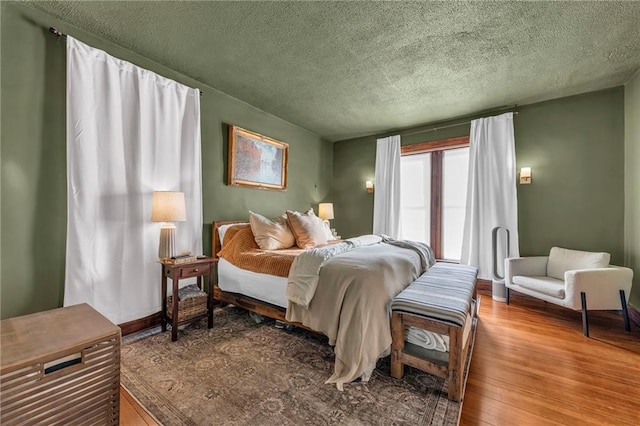 bedroom with hardwood / wood-style flooring and a textured ceiling