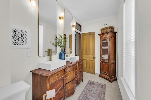 bathroom with vanity, ornamental molding, and toilet