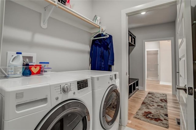 laundry room with visible vents, light wood-style floors, washing machine and dryer, laundry area, and baseboards