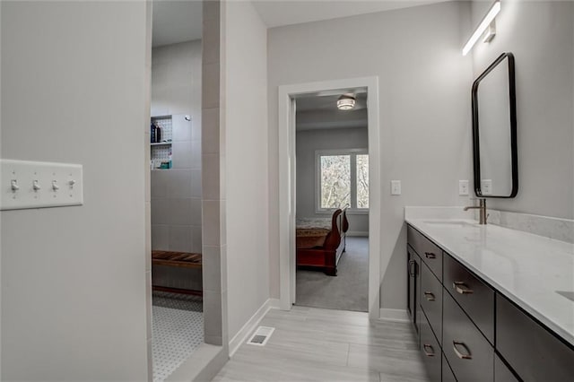 ensuite bathroom with double vanity, visible vents, ensuite bathroom, a sink, and a walk in shower