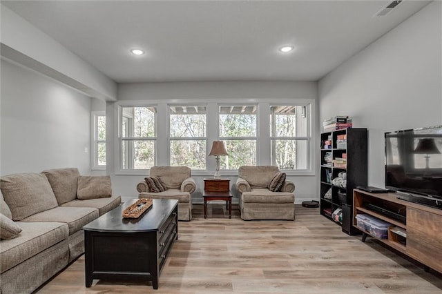 living area with light wood finished floors, visible vents, and recessed lighting