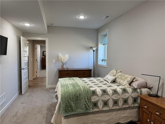 bedroom featuring light colored carpet, visible vents, and baseboards