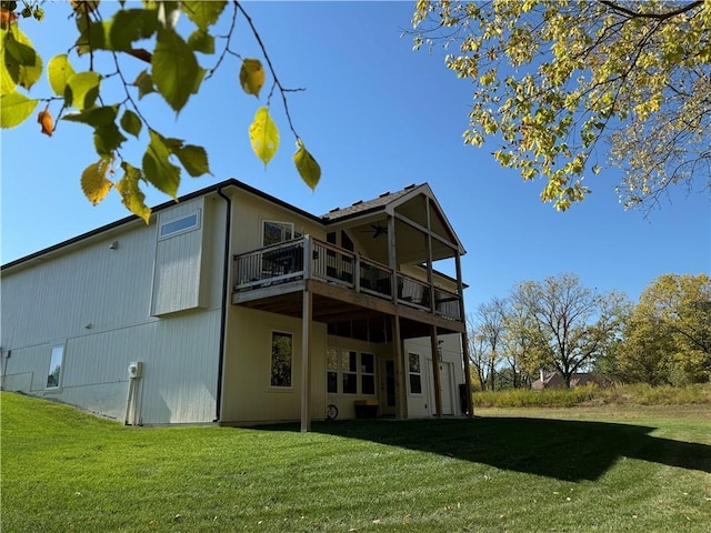 rear view of house featuring a ceiling fan, a lawn, and a wooden deck