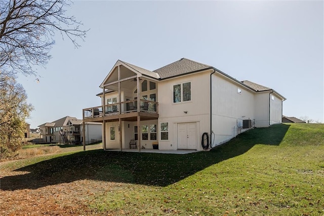 rear view of property with a yard, central AC unit, and a patio