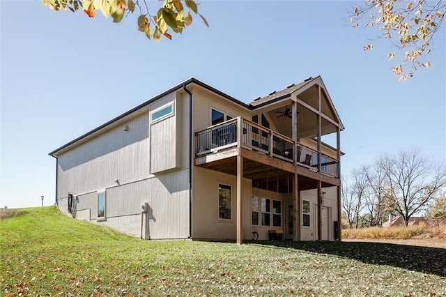 back of property with a ceiling fan and a lawn