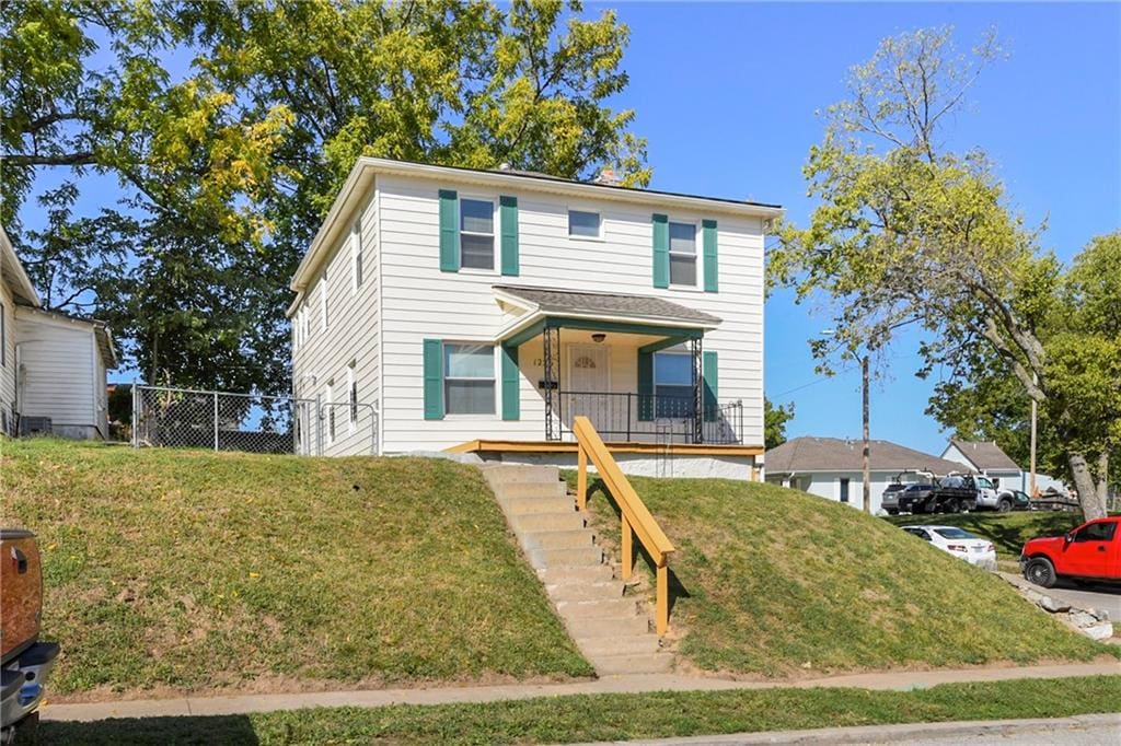 view of front facade with a front lawn and covered porch