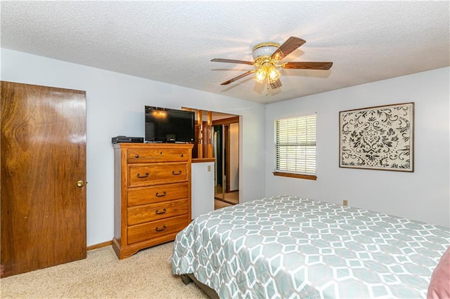 carpeted bedroom featuring ceiling fan and a textured ceiling