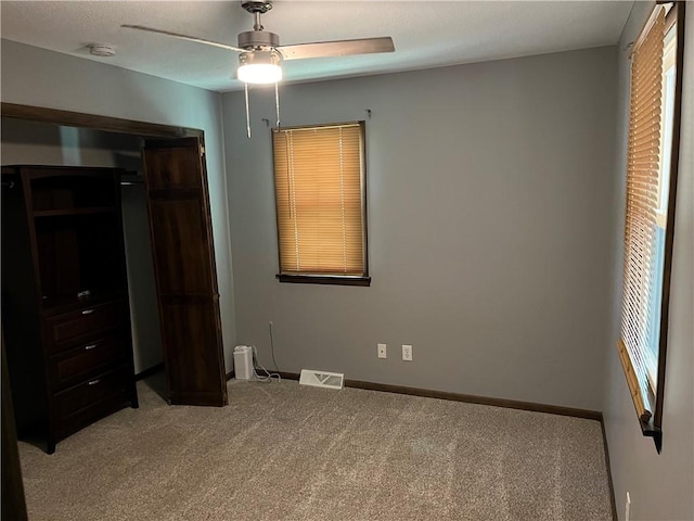 unfurnished bedroom with carpet, ceiling fan, and a closet