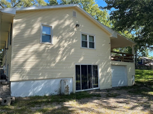 back of property featuring a lawn and a garage