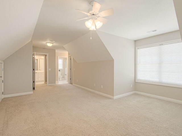 additional living space featuring light carpet, vaulted ceiling, and ceiling fan