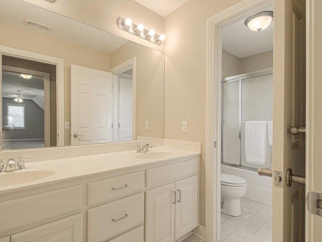 full bathroom featuring toilet, ceiling fan, vanity, and shower / bath combination with glass door