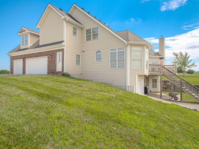 view of property exterior with a garage, a lawn, and a deck