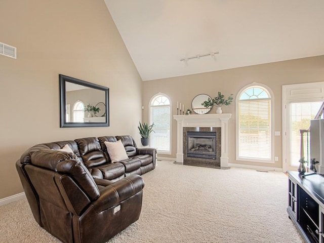 carpeted living room featuring a fireplace, high vaulted ceiling, and rail lighting