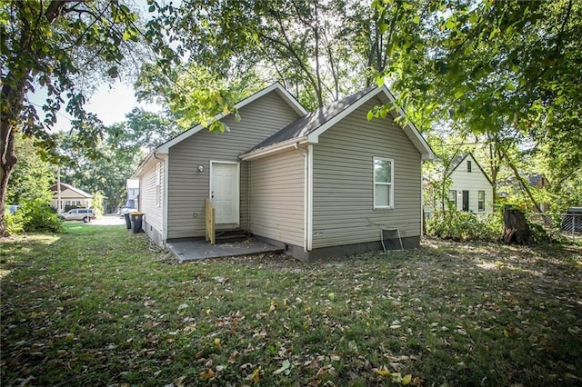 back of house featuring a patio area and a lawn