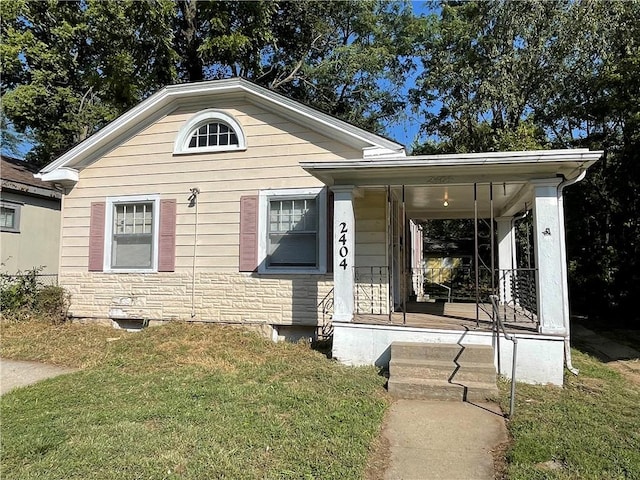 view of front of house with covered porch and a front yard