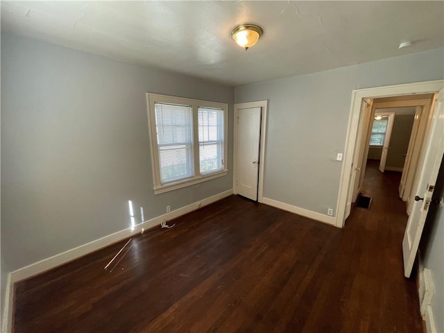 unfurnished bedroom featuring a closet and dark wood-type flooring