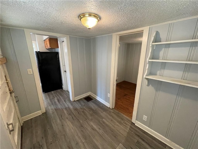 corridor featuring a textured ceiling and dark wood-type flooring