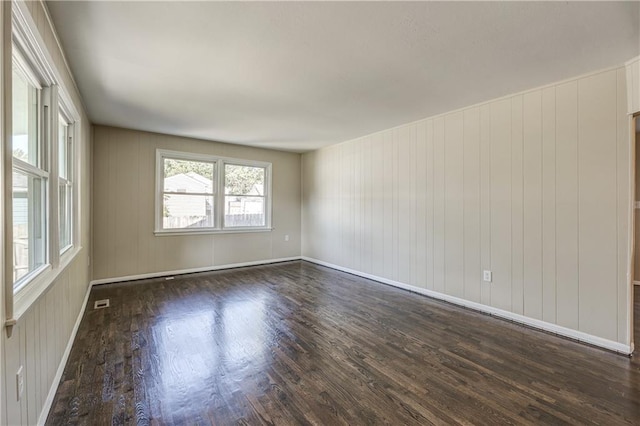 spare room with wood walls and dark hardwood / wood-style floors