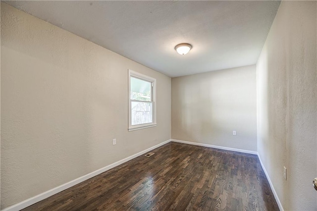 unfurnished room with dark hardwood / wood-style flooring