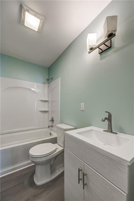 full bathroom with vanity, wood-type flooring, shower / bathing tub combination, and toilet