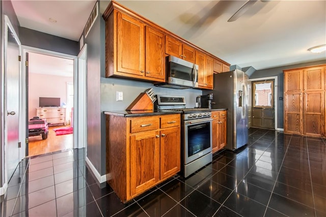 kitchen featuring appliances with stainless steel finishes and dark tile patterned floors