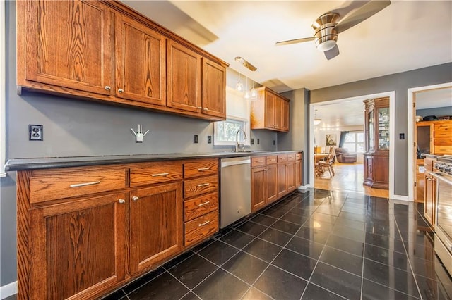 kitchen featuring ceiling fan, sink, dark tile patterned floors, stainless steel dishwasher, and decorative light fixtures