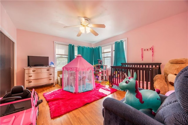 bedroom with hardwood / wood-style flooring, multiple windows, and ceiling fan