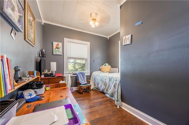 bedroom with ornamental molding and dark hardwood / wood-style flooring