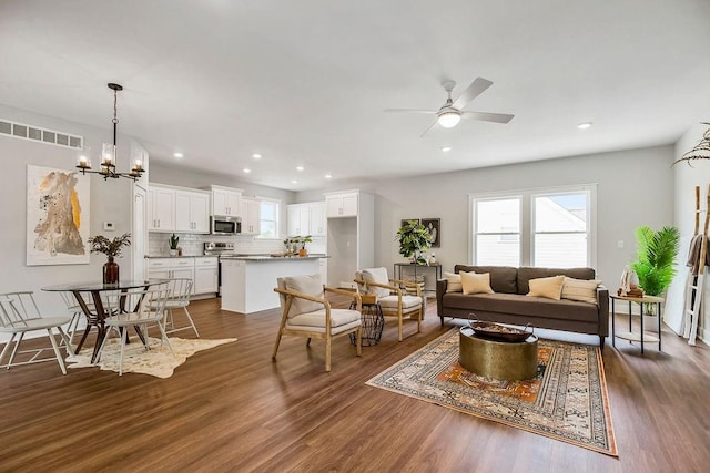 living room with dark hardwood / wood-style floors and ceiling fan with notable chandelier