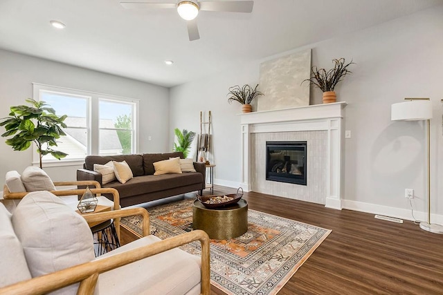 living room featuring a fireplace, dark hardwood / wood-style flooring, and ceiling fan