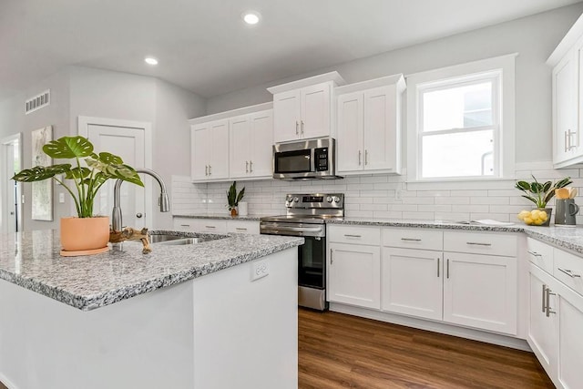 kitchen featuring visible vents, appliances with stainless steel finishes, white cabinetry, and a sink