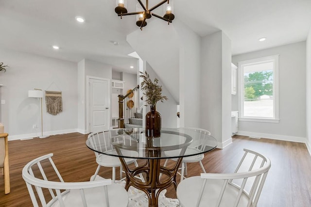 dining area with wood-type flooring and a chandelier