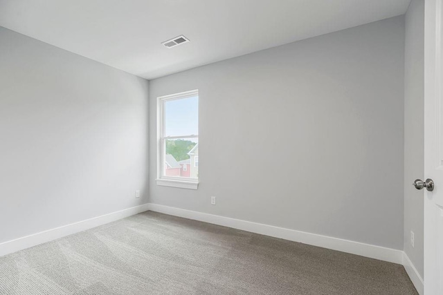 spare room featuring carpet flooring, visible vents, and baseboards