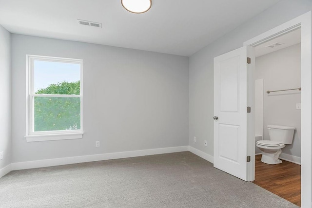 unfurnished bedroom with carpet and connected bathroom