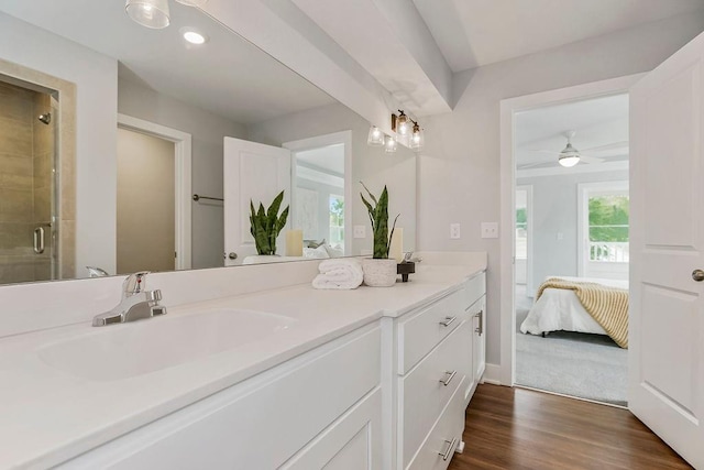 bathroom featuring vanity, hardwood / wood-style flooring, a shower with door, and ceiling fan