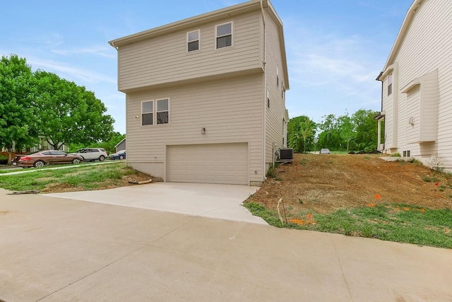 view of side of home with central air condition unit and a garage